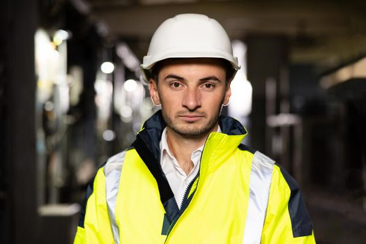 Portrait of confident electrician young worker professional standing corridor of construction site posing at camera. Heavy industry job. Engineering concept.