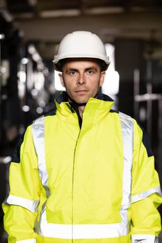 Portrait of caucasian heavy industry engineer worker posing confident to camera wearing hardhat and uniform. Business people in hard hat or safety wear. Electrician, electric worker.