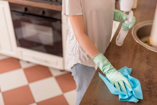 side view woman cleaning kitchen surface. High resolution photo
