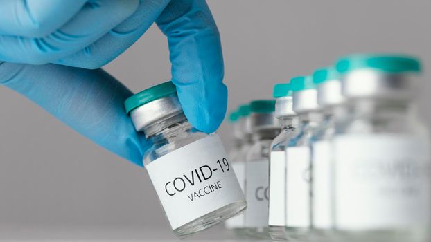 doctor holding covid 19 vaccine bottle. High resolution photo