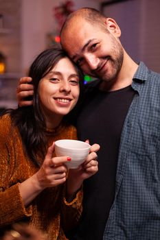 Portrait of joyful family looking into camera enjoying christmas holiday together in xmas decorated kitchen. Haapy family hugging while celebrating wintertime during winter season