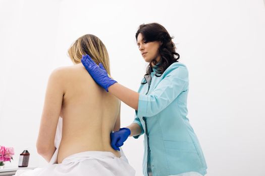 The chiropractor regulates the patient's shoulder. The girl receives a physiotherapy massage during a session. Alternative medicine treatment and rehabilitation of patients.