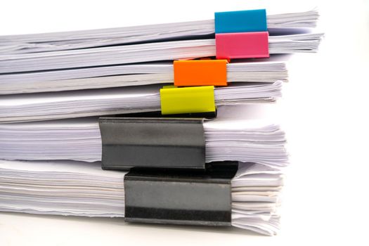 Stack of report paper files in business office clips.