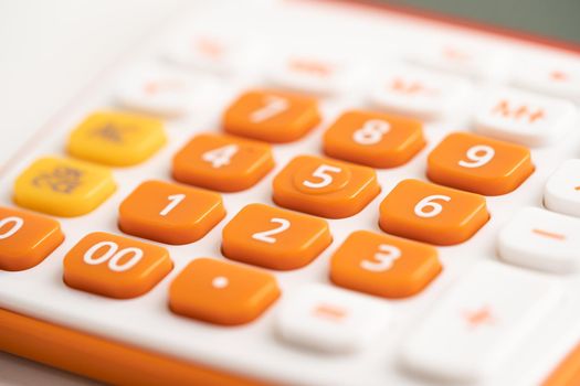 Number pad on orange color calculator for account finance in office.