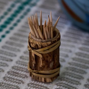 a jar with wooden toothpicks is on the table close-up photo