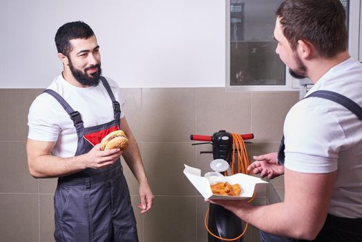 Worker wearing uniform eating burger during a lunch break