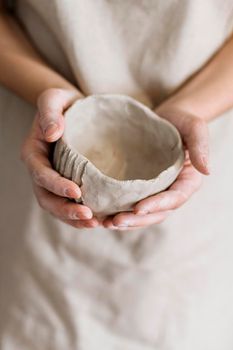 woman holding pottery pieces made by herself. High resolution photo