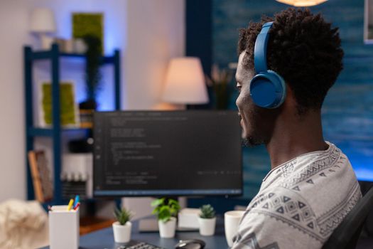 African american programmer with headset programming website code on computer working remote from home. Employee man coding business security server. Concept of software development
