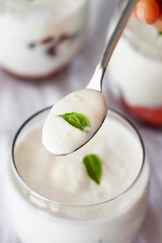 hand holding spoon with yogurt. High resolution photo