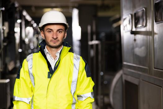 Portrait of a frontline essential worker in a warehouse. Caucasian business people in hard hat or safety wear. Professional male industry engineer specialist.