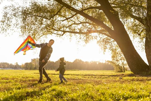 father son playing kite park. High resolution photo