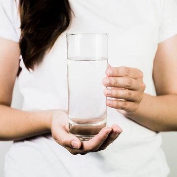 crop female hands holding glass water. High resolution photo