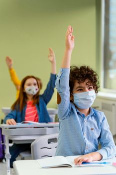 front view children raising their hands class. High resolution photo