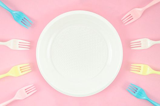 colorful plastic dishes pink background. High resolution photo