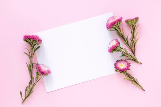 high angle view flowers blank paper sheet pink backdrop. High resolution photo