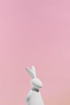 white rabbit figurine pink background. High resolution photo