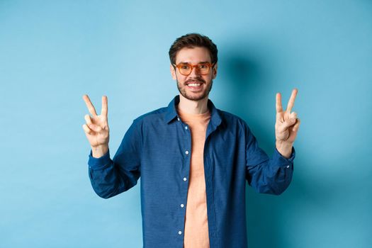 Cheerful guy posing with peace sign in new glasses, concept of eyewear shop promotion.