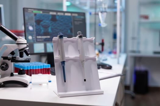 Medical microbiology hospital laboratory equipped with medicine biological micropipette and vacutainer blood sample standing on table during biochemistry experiment. Healthcare investigation