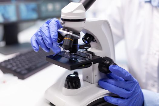 Pharmacist woman doctor analyzing coronavirus dna test using medical microscope working in microbiology hospital laboratory. Specialist researcher discovering bacteriology disease vaccine