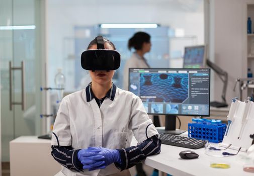 Professional scientist wearing virtual reality glasses using medical inovation in lab. Team of researchers working with equipment device, future, medicine, healthcare, professional, vision, simulator.