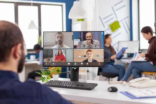 Immobilized entrepreneur project manager in wheelchair talking on videocall during online meeting discussing with business partners working in financial company, start up office with modern technology.