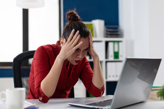 Frustrated businesswoman having problem with broken slow laptop, in corporate workplace. Stressed entrepreneur looking annoyed by hard work or system crash. Exhausted employee.