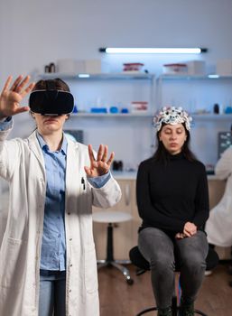 Laboratory doctor experiencing virtual reality using vr goggles in medical neurological research lab. Physician therapist using medical innovation equipment device glasses, analysing brain scan.