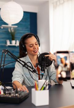 Vlogger on air during her podcast channel using mixer and professional microphone. Online show production internet broadcast host streaming live video, recording digital social media communication