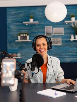 Social media star woman holding professional microphone while recording podcast for youtube channel. Creative online show On-air production internet broadcast host streaming live video