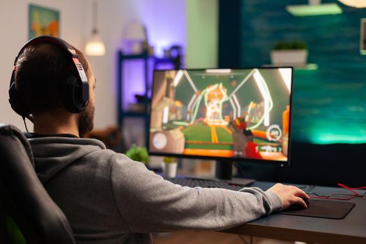 Professional player with headset playing videogame with modern graphics for shooter competition. Online streaming cyber performing during gaming tournament using technology network wireless