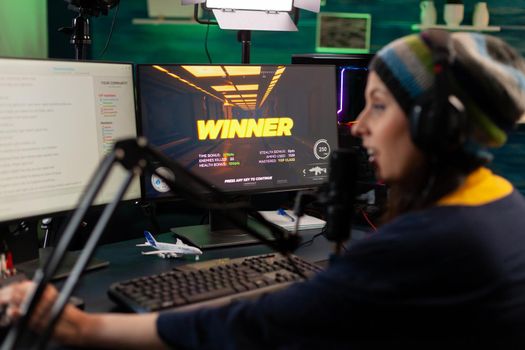 Streamer woman winning virtual videogame competition use professional equipment in home studio. Online streaming cyber performing during gaming tournament using technology network wireless