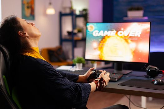 Player woman winning space shooter game using virtual reality goggles playing games with modern joystick. Professional gamer streaming online videogames with new graphics on powerful computer