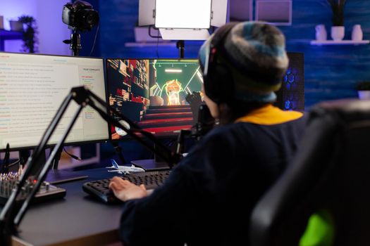 Pro woman gamer with headphone streaming videogames in gaming home studio. Professional player talking with other players online for game competition playing on powerful computer
