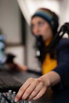 Close up of streamer wearing headset and talking into microphone with streaming comunity using professional mixer. Pro gamer playing online videogames with new graphics on powerful computer