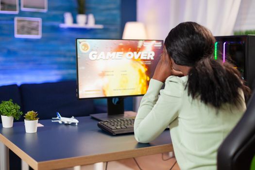 Disappointed sad african woman after losing online game competition Angry professional gamer gaming over during an space shooter online video game.
