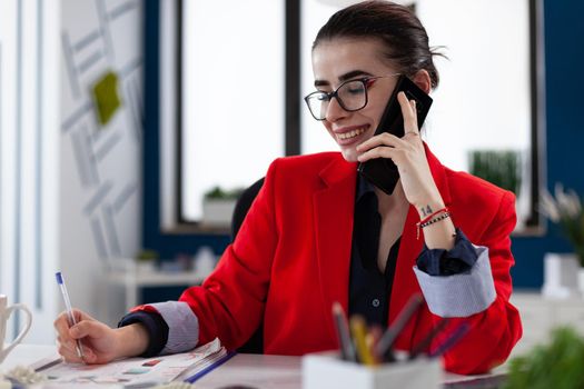 Financial adviser discussing with client during phone call conversation, looking at official documents. Company manager answering executive questions during mobile call sitting at desk in workplace .