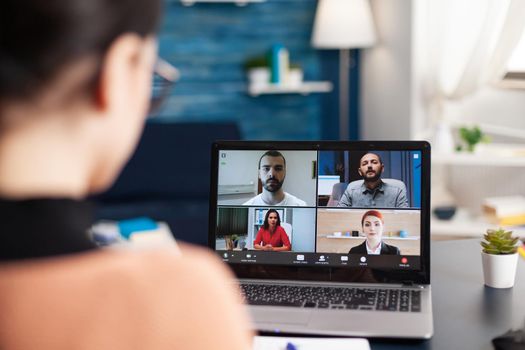 Student studying lifestyle course with her school group during online videocall meeting using laptop computer. Young woman having remote education during coronavirus quarantine