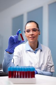 Chemist doctor analyzing dna blood using medical vacutainer working at microbiology experiment in biotechnology medicine hospital laboratory. Researcher woman researching biochemistry expertise