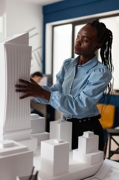 Architecture african american constructor at designer job working on building model plan design maquette. Development worker looking at layout for modern engineering project