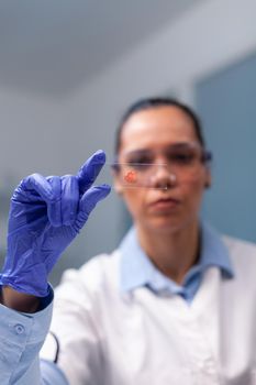 Microbiological doctor holding blood test sample investigating virus environment in microbiological biological hospital laboratory. Specialist scientist working at antiviral treatment