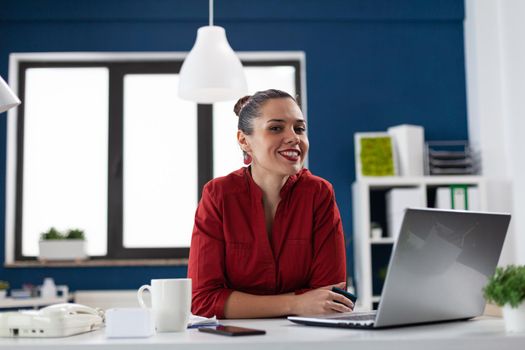 Successful businesswoman in corporate financial company office, looking at camera sitting at desk. Entrepreneur start up leadership. Financial adviser worker with with charts on clipboard.