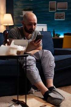 Depressed, worried man reading renter notification for unpaid bank bills news received on smartphone. Disappointed, frustrated, angry, annoyed desperate male reading digital eviction notice document