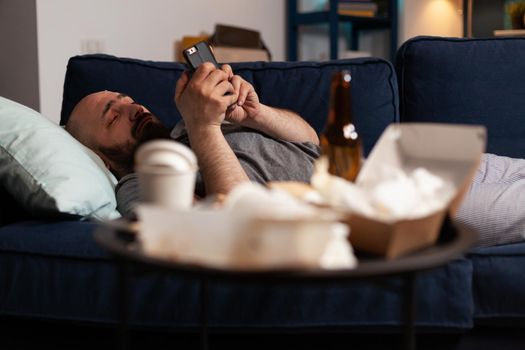 Sad unhappy alone depressed shocked depresive man browsing on smartphone, struggling with mental health going through a major depression. Anxious frustrated male reading digital bank notice