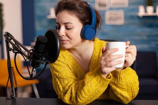 Woman vlogger recording to camera tutorial about lifestyle in home podcast studio during livestreaming. On-air online production internet broadcast show host streaming live content for social media.