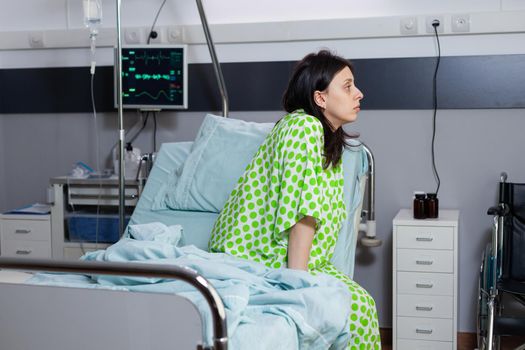 Hospitalized patient lying in bed during illness consultation waiting for physician doctor in hospital ward. Upset patient recovering after breathing disorder and surgery