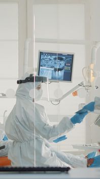 Stomatology nurse giving dental x ray to dentist in cabinet for patient teeth consultation at oral clinic. Caucasian professional orthodontic staff using modern dentistry equipment