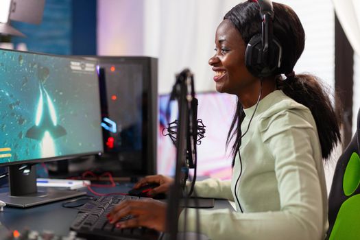 Competitive e-sport professional gamer player talking into microphone at night. Streaming viral video games for fun using headphones and keyboard for online championship.