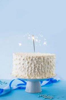 white birthday cake with burning sparkler. High resolution photo
