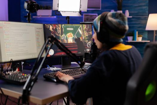 Esport streamer playing shooter game with other players on streaming chat for virtual games competition. Gamer making online videogames with new graphics on powerful computer