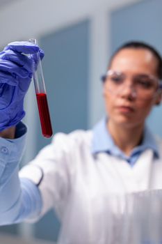 Specialist chemist holding clinical blood test tube analyzing biotechnology virus researcher studying biochemistry experiment. Scientific doctor discovering healthcare expertise in medical laboratory